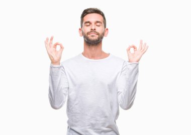 Yakışıklı delikanlı izole arka plan üzerinde dinlenmek ve gülümseyen gözlerle parmak ile meditasyon jest yapıyor kapalı. Yoga kavramı.