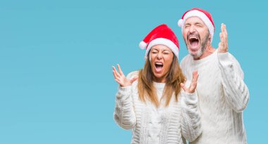 Arka plan deli kutluyor orta yaş İspanyol çift üzerinde Noel şapka izole ve crazy arms ile başarı için kaldırdı ve heyecanlı çığlık gözler kapalı. Kazanan kavramı