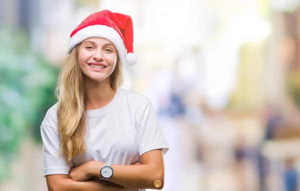 年轻美丽的金发女子戴着圣诞节帽子在孤立的背景愉快的脸微笑着交叉的胳膊看着相机 积极的人 — 图库照片