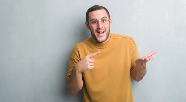 Homem Caucasiano Jovem Sobre Parede Grunge Cinza Muito Feliz Apontando — Fotografia de Stock