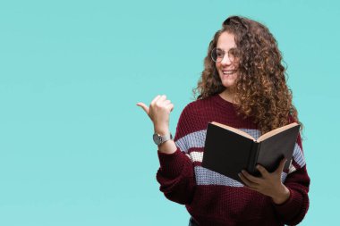 Genç esmer kız gözlüklü işaret ve başparmak kadar mutlu yüz gülümseyen tarafı ile gösteren izole arka plan üzerine bir kitap okuma