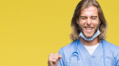 Genç yakışıklı Doktor adam izole arka kolları olan başarı için heyecan üzerinde uzun saçlı zafer kutluyor gülümseyen kaldırdı. Kazanan kavramı.