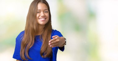 Tebrik ve konuksever dost sunan karşılıklı gülümseyen izole arka plan üzerinde mavi t-shirt giyen genç güzel esmer kadın. Başarılı iş.