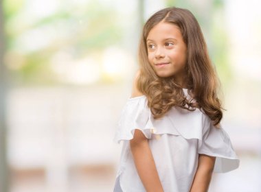 Uzak tarafına gülümseme ile yüzünde, doğal ifade esmer Latin kız. Kendine güvenen gülüyor.
