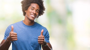 El ile pozitif jest yapıyor izole arka plan başarı işareti üzerinde Afro Amerikalı adam başparmak gülümseyen ve mutlu. Neşeli bir ifadeyle, kazanan jest kameraya bakıyor.