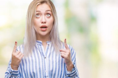 Sarışın genç kadın izole arka plan üzerinden hayran ve yukarıya bakıp parmakları ile işaret şaşırttı ve silah kaldırdı.