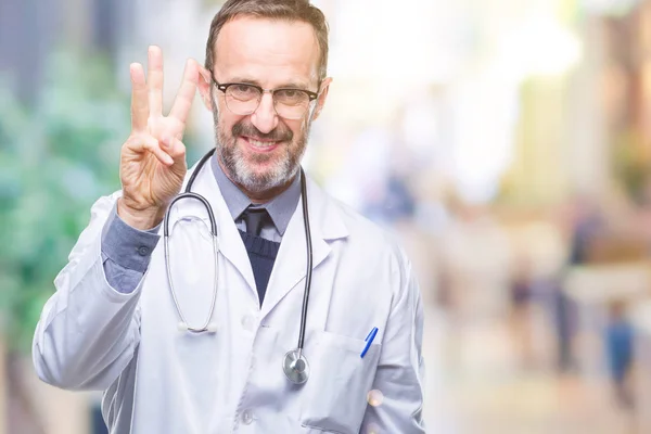 中年老年医生男子穿着医疗制服孤立的背景显示和手指第三 同时微笑着自信和快乐 — 图库照片