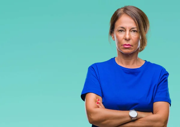 Middle age senior hispanic woman over isolated background with serious expression on face. Simple and natural looking at the camera.