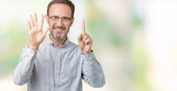 ハンサムな中年エレガントな年配の男性でメガネをかけて分離を示す背景と自信を持って 幸せな笑みを浮かべて 指で上向きナンバーシックス — ストック写真