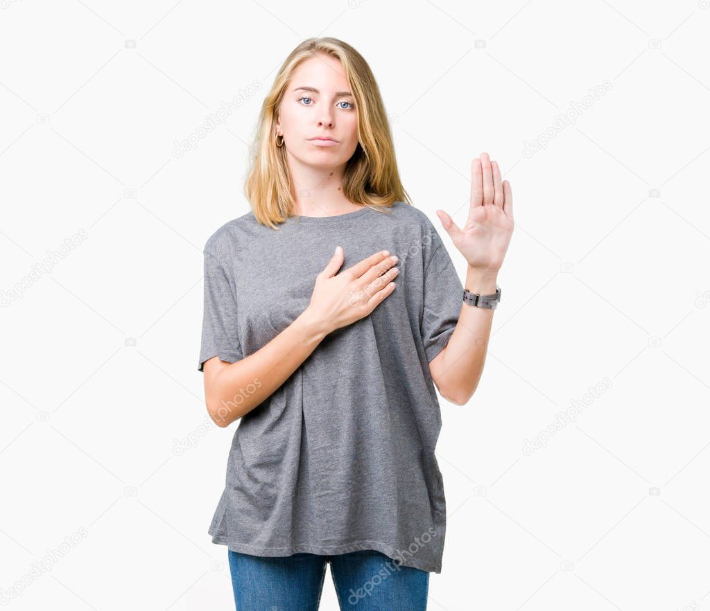 Beautiful young woman wearing oversize casual t-shirt over isolated background Swearing with hand on chest and open palm, making a loyalty promise oath