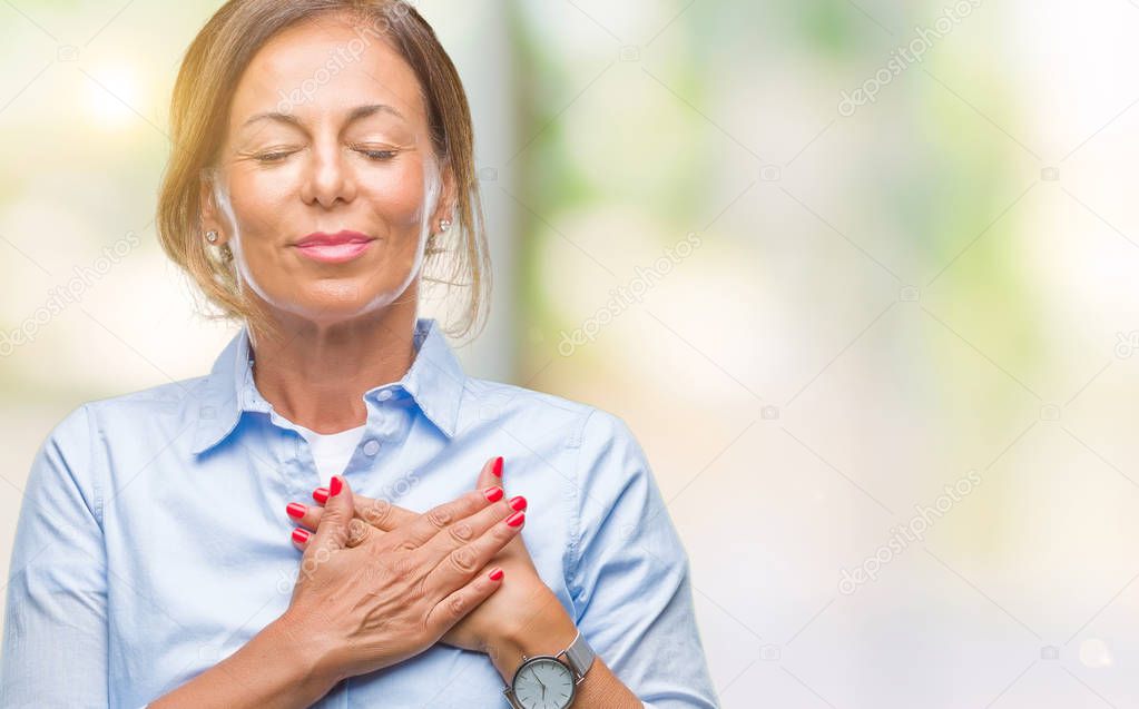 Middle age senior hispanic woman over isolated background smiling with hands on chest with closed eyes and grateful gesture on face. Health concept.