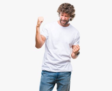 Gülümseyen ve başarı için çığlık yakışıklı İspanyol modeli izole arka plan çok mutlu ve heyecanlı kaldırdı, silah ile kazanan jest yapıyor adam. Kutlama kavramı.