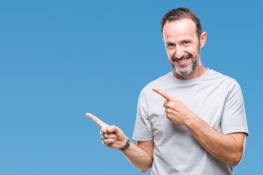 Orta yaş üst düzey ağarmış adam gülümseyerek ve iki elleri ve parmakları ile tarafına işaret kamera bakarak izole arka plan üzerinde.