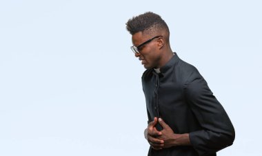 Genç Afrikalı-Amerikalı rahip adam mide üzerinde el ile izole arka plan üzerinde çünkü mide bulantısı, ağrılı hastalık hasta hissediyor. Ağrısı kavramı.