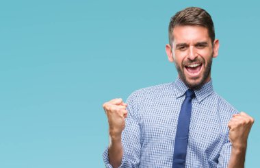 Gülümseyen ve başarı için çığlık genç yakışıklı iş adamı izole arka plan çok mutlu ve heyecanlı kaldırdı, silah ile kazanan jest yapıyor üzerinde. Kutlama kavramı.