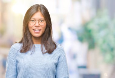 Yüzünde mutlu ve güzel bir gülümseme ile izole arka plan üzerinde kış kazak giyen genç Asyalı kadın. Şanslı kişi.