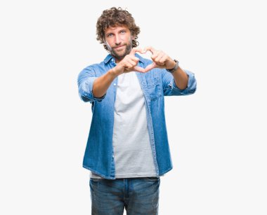 Yakışıklı İspanyol modeli adam aşık kalp simgesi ve elleriyle şekil gösteren gülümseyen izole arka plan üzerinde. Romantik kavramı.