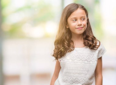 Esmer Latin kız görünümlü yan ve dik dik bakma uzağa düşünce gülümseyen.