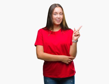 Yüzünde kocaman bir gülümseme ile izole arka plan üzerinde genç güzel beyaz kadın kameraya bakarak yan el ve parmak ile işaret.