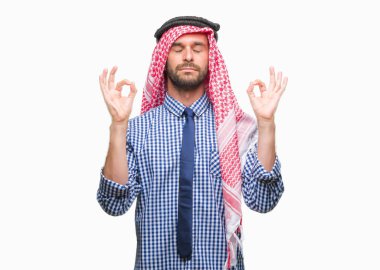 Genç yakışıklı Arap iş adamı giyen keffiyeh izole arka plan üzerinde dinlenmek ve gülümseyen gözlerle kapalı parmak jestle meditasyon yapıyor. Yoga kavramı.