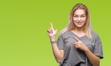 Gülümseyen ve iki elleri ve parmakları ile tarafına işaret kamera bakarak izole arka plan üzerinde beyaz kadın.