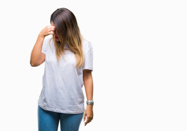 Genç güzel kadın casual beyaz t-shirt üzerinde izole arka plan duygu yorgunluk ve baş ağrısı gözleri ve burun sürtme yorgun. Stres ve hayal kırıklığı kavramı.