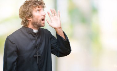 Bağırarak ve ağzı üzerinde el ile yan için çığlık izole arka plan yakışıklı İspanyol Katolik rahip adam. İletişim kavramı.