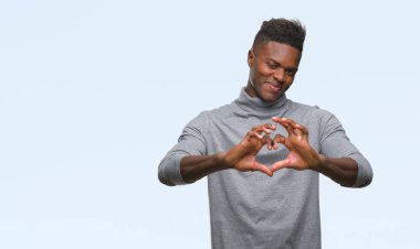 Afrikalı-Amerikalı genç aşık kalp simgesi ve elleriyle şekil gösteren gülümseyen izole arka plan üzerinde. Romantik kavramı.