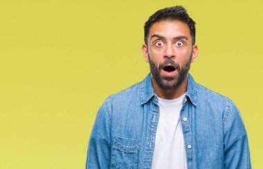 Yetişkin İspanyol adam korkuyor ve şok sürpriz ifade ile izole arka plan üzerinde korku ve yüz heyecanlı.