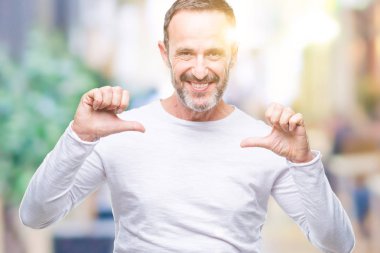 Yüzünde gülümseme ile kendinden emin görünüyorsun, kendini gururlu ve mutlu parmakları ile işaret izole arka plan üzerinde beyaz t-shirt giyen orta yaş ağarmış komuta sizde.