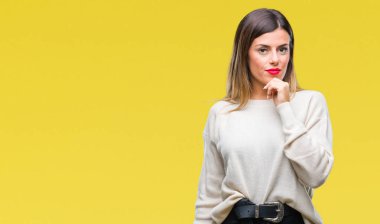 Genç güzel kadın rahat beyaz kazak emin çapraz kollar ve çeneme kaldırdı el ile gülümseme ile kameraya bakarak izole arka plan üzerinde. Pozitif düşünce.