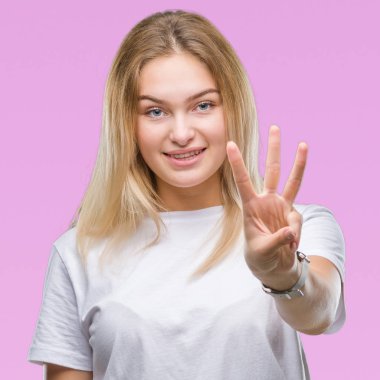 Gösterilen ve parmakları ile işaret izole arka plan üzerinde beyaz kadın kendinden emin ve mutlu gülümseyerek iken üçüncü.