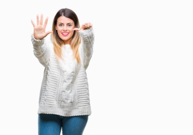 Genç güzel kadın rahat beyaz kazak gösterilen ve parmakları ile işaret izole arka plan üzerinde kendinden emin ve mutlu gülümseyerek süre 6 numara.