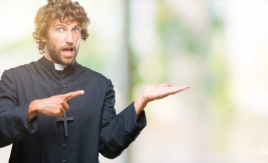 Yakışıklı İspanyol Katolik rahip adam üzerinden hayran ve el ile sunulması ve parmak ile işaret ederken kameraya gülümseyen izole arka plan.