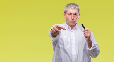 Yakışıklı komuta sizde holding kredi kartı kamera ve size parmak ile işaret izole arka plan üzerinde el işareti, pozitif ve kendinden emin bir jest ön