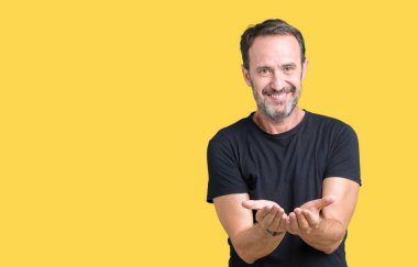 Yakışıklı orta yaş ağarmış üst düzey adam izole alma veya jest vererek birlikte el avuç içi ile gülen arka plan. Ayrı tutma ve koruma