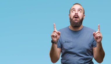 Genç beyaz hipster adam izole arka plan üzerinden hayran ve yukarıya bakıp parmakları ile işaret şaşırttı ve silah kaldırdı.