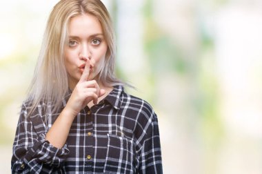 Genç Sarışın kadın dudaklarında parmak ile sessiz olmanı izole arka plan yüzünden. Sessizlik ve gizli kavramı.