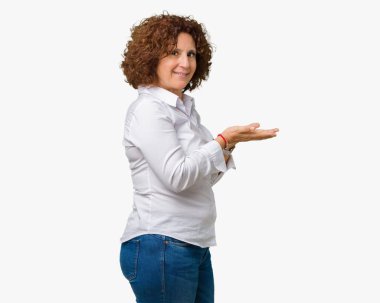 Güzel orta ager üst düzey businees kadın izole arka plan yüzünden el ve reklam mutlu ve kendinden emin gülümseyen sunulması avuç, yanında işaret