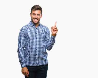 Kameraya bakarak yan el ve parmak ile işaret eden genç yakışıklı adam yüzünde kocaman bir gülümseme ile izole arka plan üzerinde.