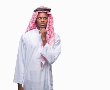 Geleneksel keffiyeh çene düşünme hakkında soru, dalgın ifade üzerine el ile izole arka plan üzerinde giyen genç Arapça Afrika adam. Düşünceli yüzüyle gülümsüyor. Şüphe kavramı.