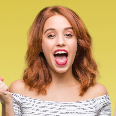 İzole arka plan kutlama üzerinde genç güzel kadın şaşırttı ve başarı için kaldırdı kollarını açarak hayret ve gözleri açık. Kazanan kavramı.