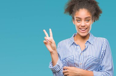 Mutlu yüz zafer işareti yaparken kameraya göz kırpıyor ile gülümseyen izole arka plan üzerinde genç afro Amerikalı kadın. İki numaralı.