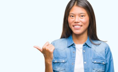 Genç Asyalı kadın arıyorum ve başparmak yanında yukarıyı mutlu yüz ile gülümseyen izole arka plan üzerinde.