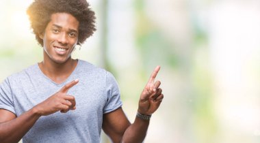 Gülümseyen ve iki elleri ve parmakları ile tarafına işaret kamera bakarak izole arka plan üzerinde Afro Amerikalı adam.