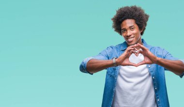 Kalp simgesi ve elleriyle şekil gösterilen aşık gülümseyen izole arka plan üzerinde Afro Amerikalı adam. Romantik kavramı.