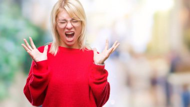 Genç güzel sarışın kadın giyiyor kazak ve gözlük kızgın ve silah ile başarı için deli kutluyor izole arka plan üzerinde kaldırdı ve heyecanlı çığlık gözler kapalı. Kazanan kavramı