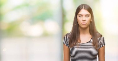 Yüzünde ciddi bir ifade ile genç güzel İspanyol kadın. Basit ve doğal kameraya bakıyor.