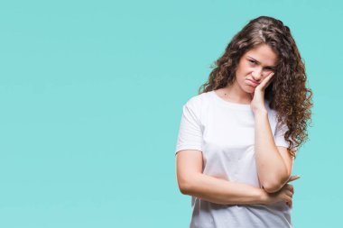 Düşünme izole arka plan bakmaktan rahat t-shirt giyen güzel esmer kıvırcık saçlı Genç kız yorgun ve sıkılmış çapraz silah depresyon sorunları ile.