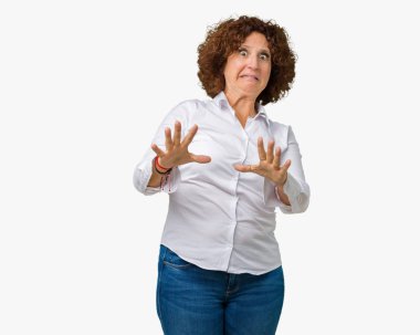 Şokta bağırarak güzel orta ager üst düzey businees kadın izole arka plan korkuyor ve korku ifade dur hareketi el ile ile çok korkmuş. Panik kavramı.